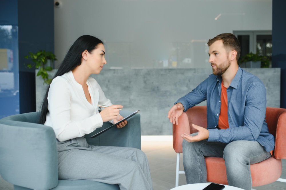 Psychologist counseling a male patient during a therapy session